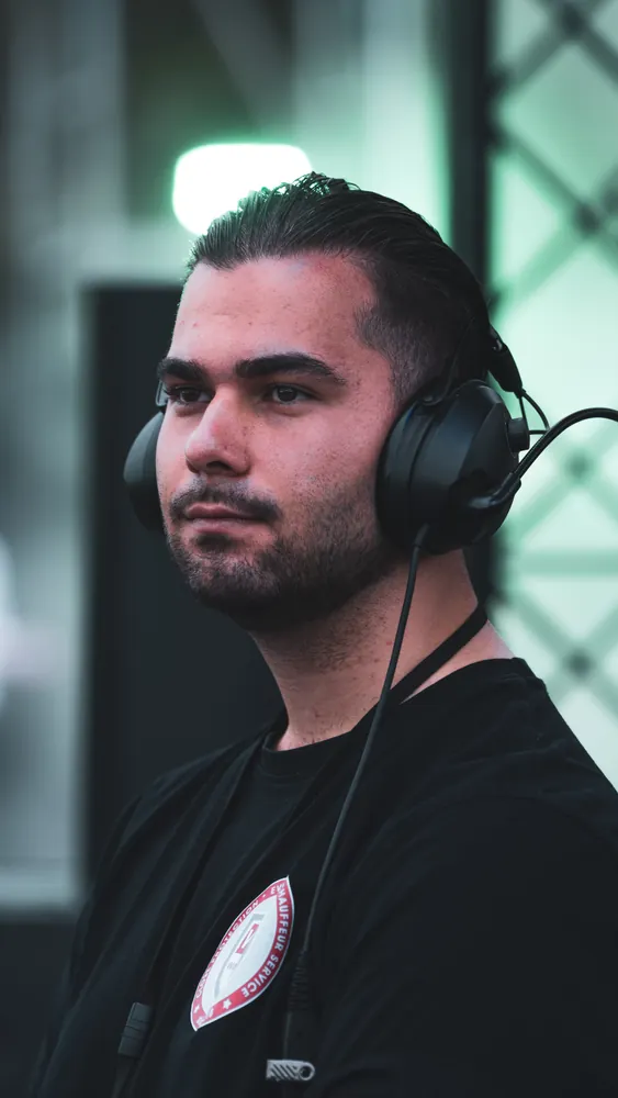 DJ mit Kopfhörern, von der Seite fotografiert