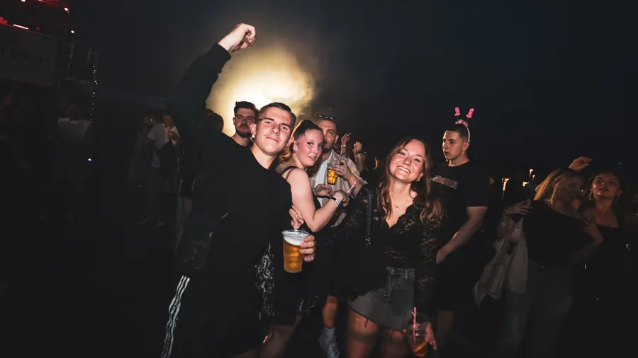 Freunde feiern gemeinsam in der nächtlichen Crowd